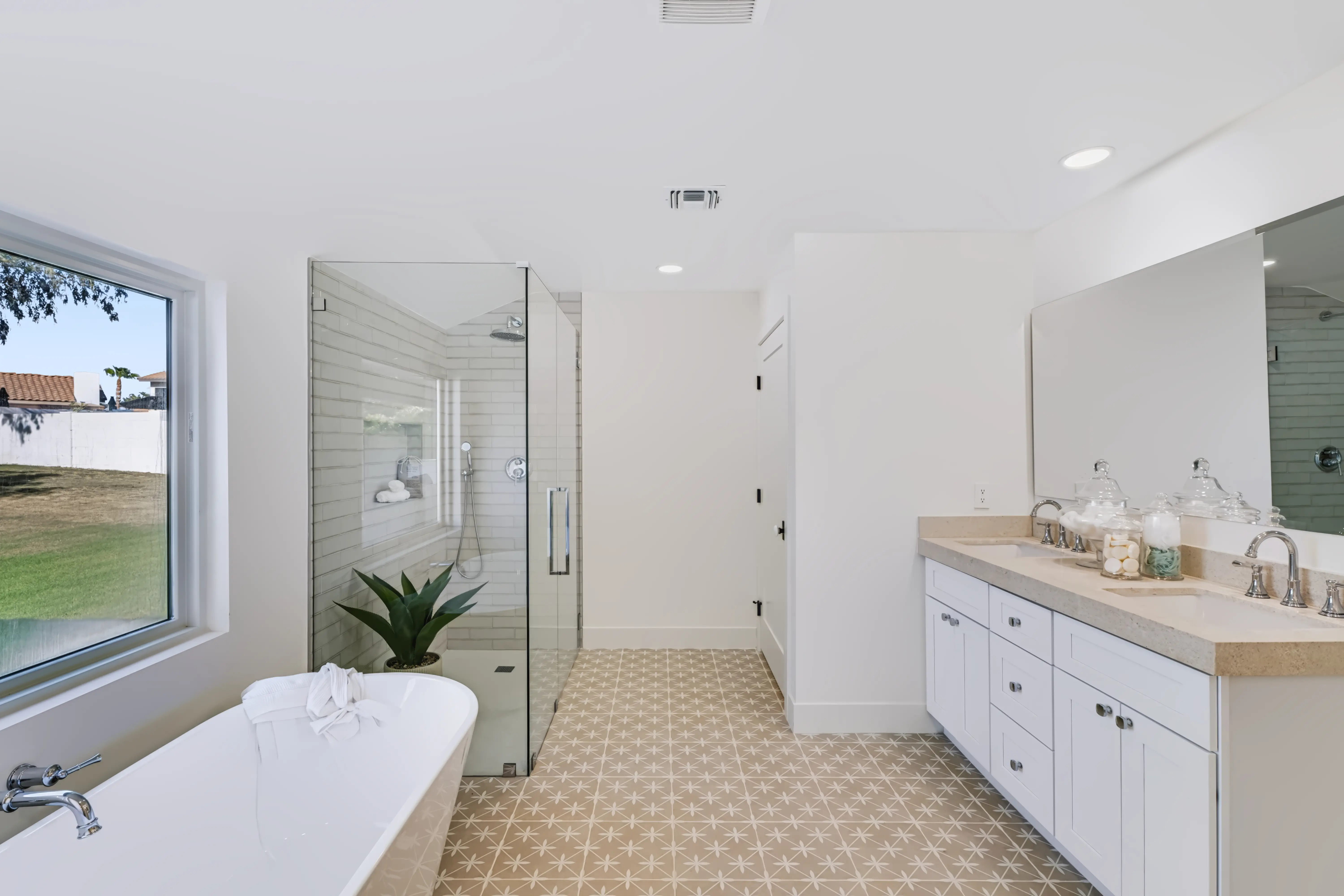 Primary bath with a freestanding tub, a patterned cement-tile floor and a glass shower